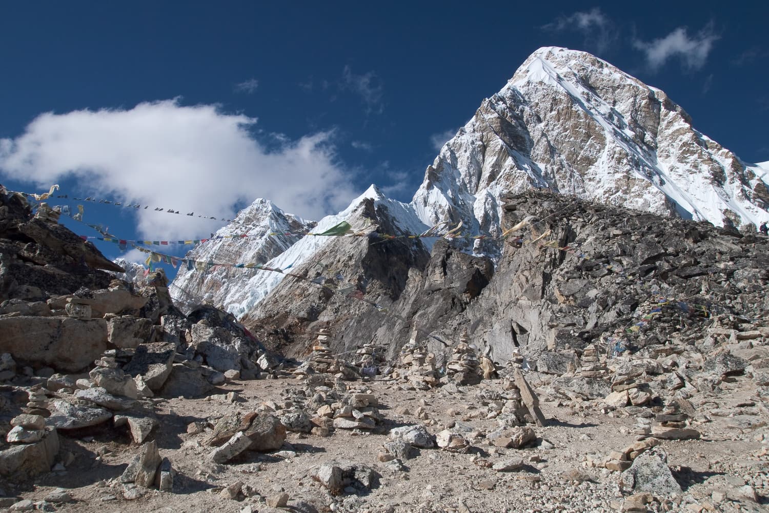 Prayer flags and cairns on Kala Patthar with the pyramid of Pumori behind