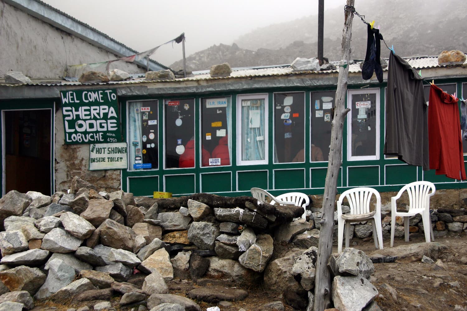 The Sherpa Lodge teahouse in Lobuche, with prayer flags and mountains behind