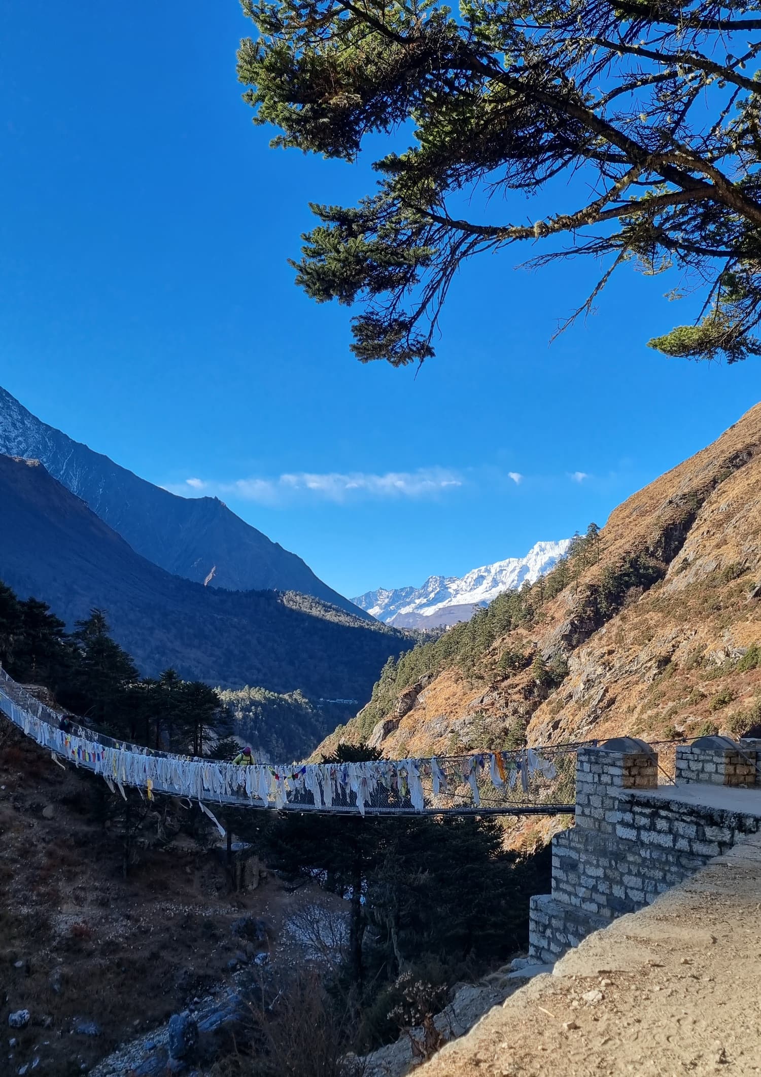 A prayer-flag-draped suspension bridge high above the Dudh Koshi gorge below Namche